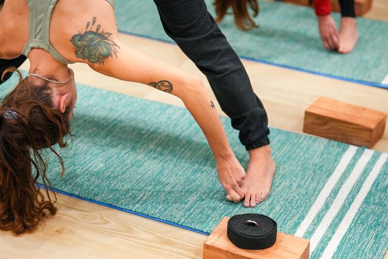 Dettaglio di pratica yoga con blocchi e cinghie