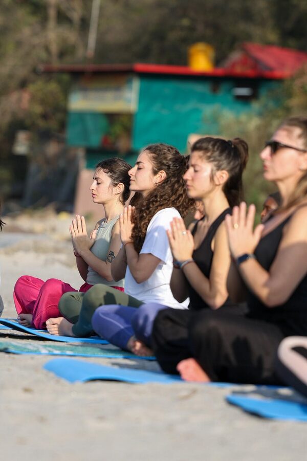 Preghiera di gruppo sulla spiaggia del Gange